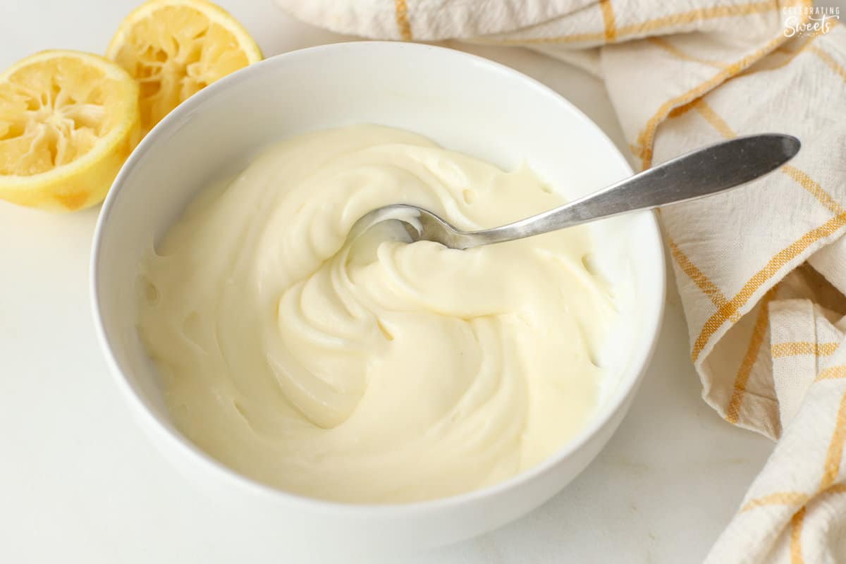 Lemon cream cheese frosting in a white bowl.