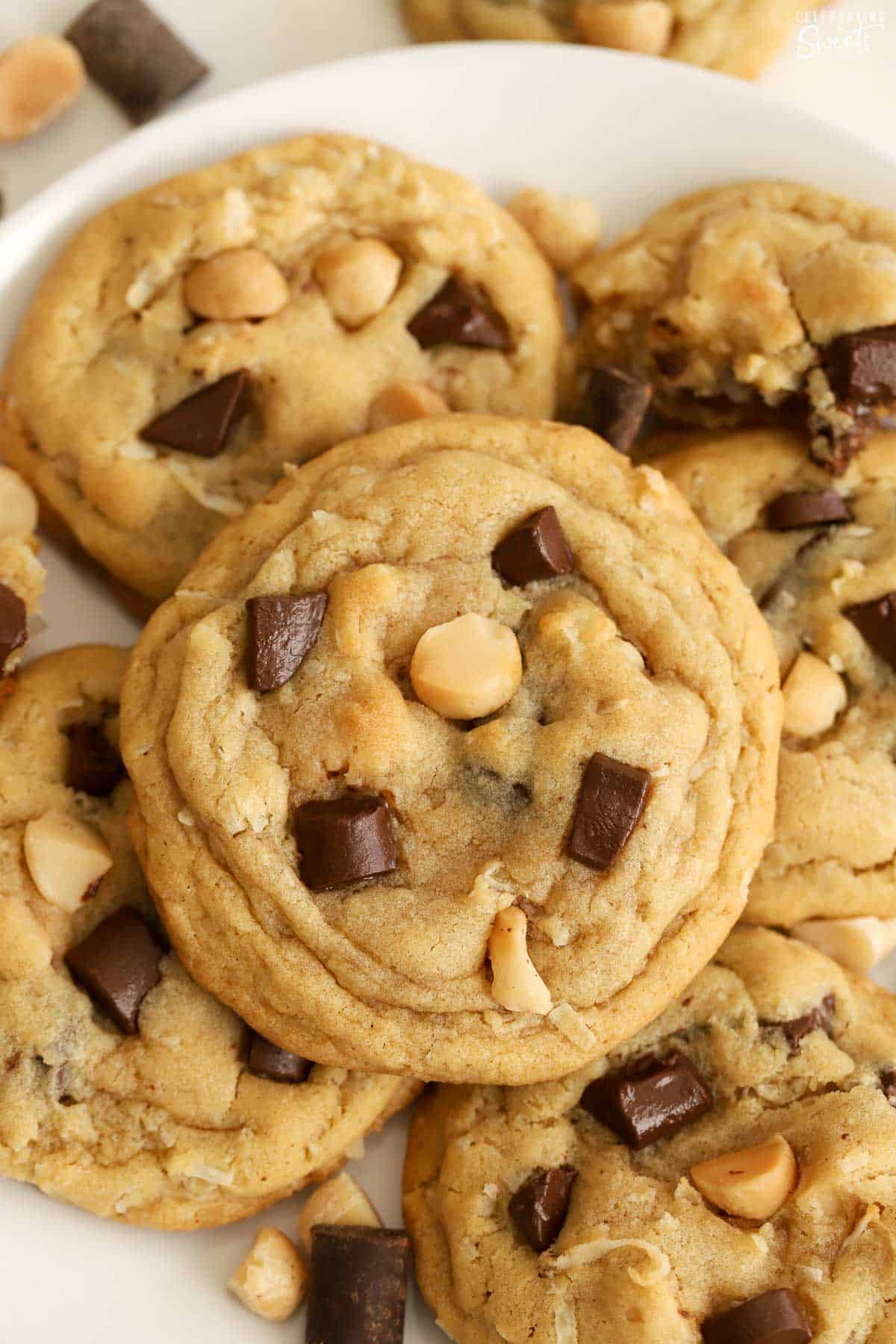 Coconut chocolate chip cookies piled on a round white plate.