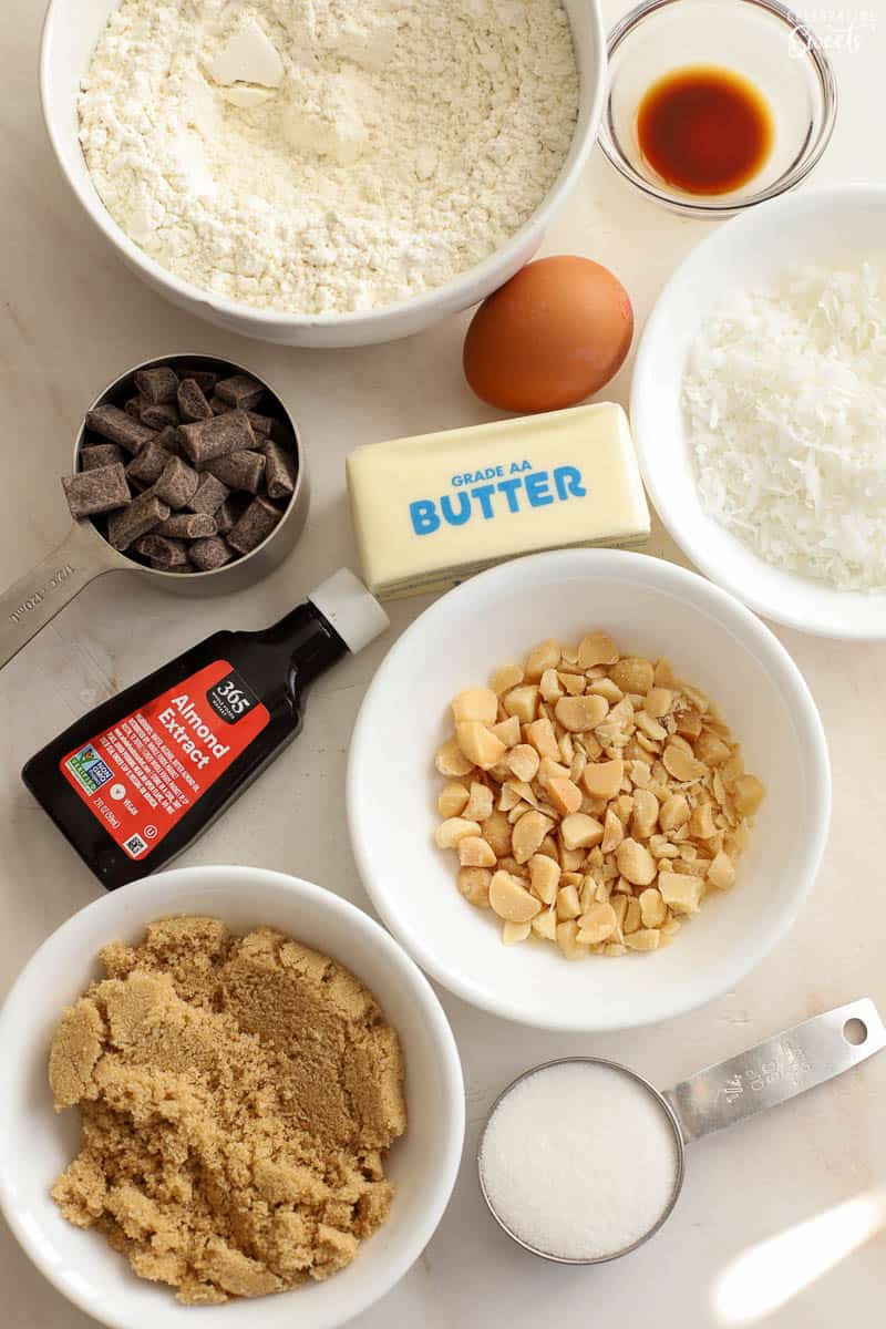 Ingredients for coconut chocolate chip cookies: butter, sugars, egg, flour, nuts, coconut, chocolate.