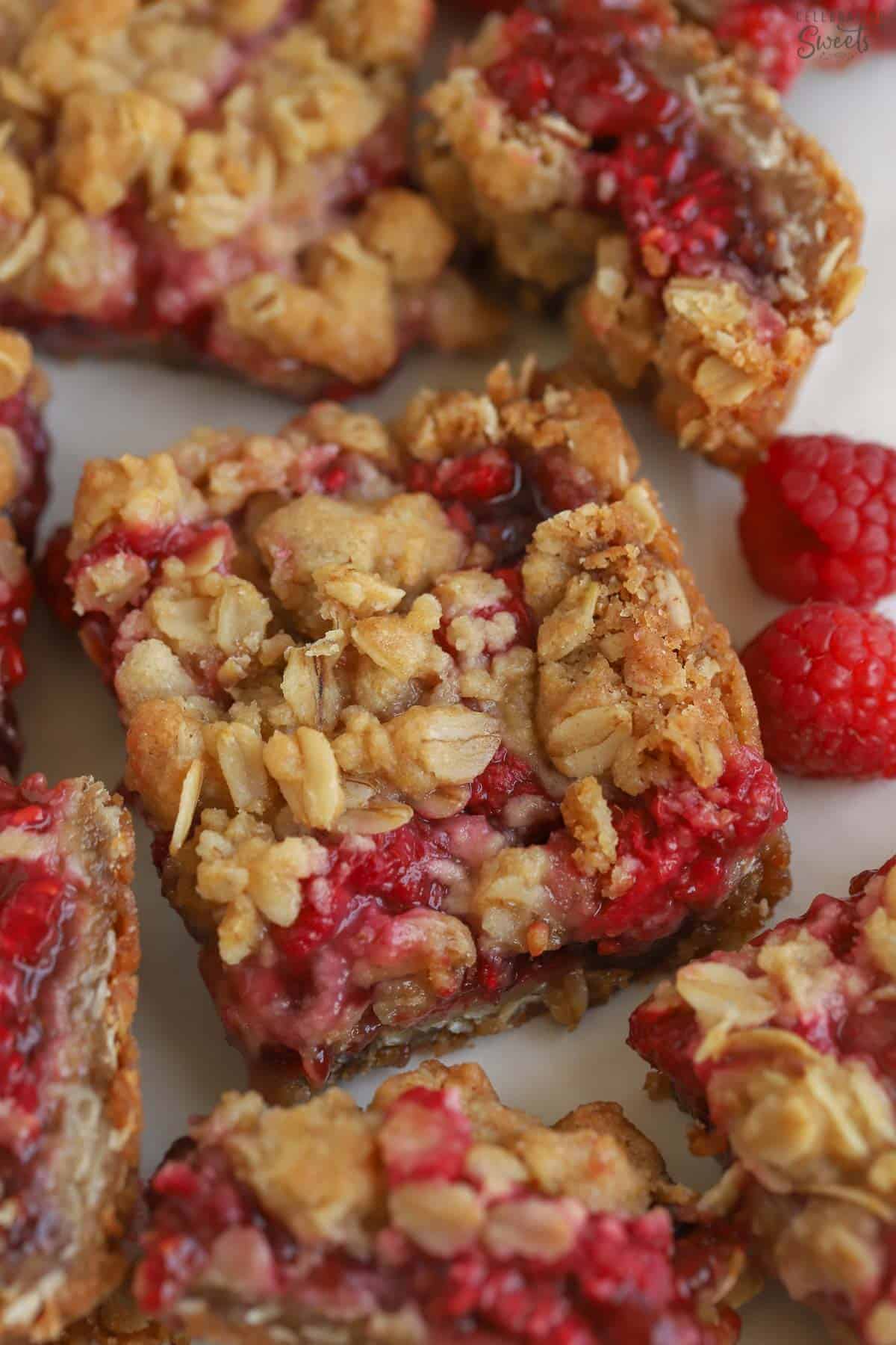 Closeup of a raspberry bar on parchment paper.