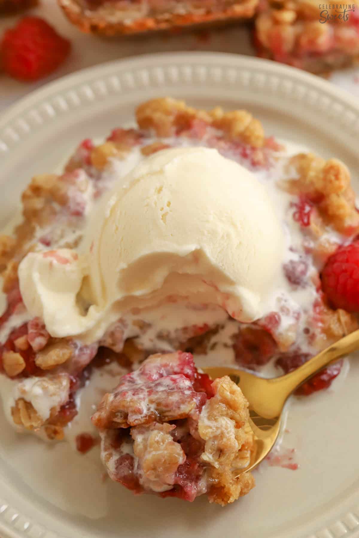 Raspberry bar on a plate topped with vanilla ice cream.
