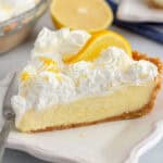 Slice of lemon cream pie on a white plate with a silver fork.