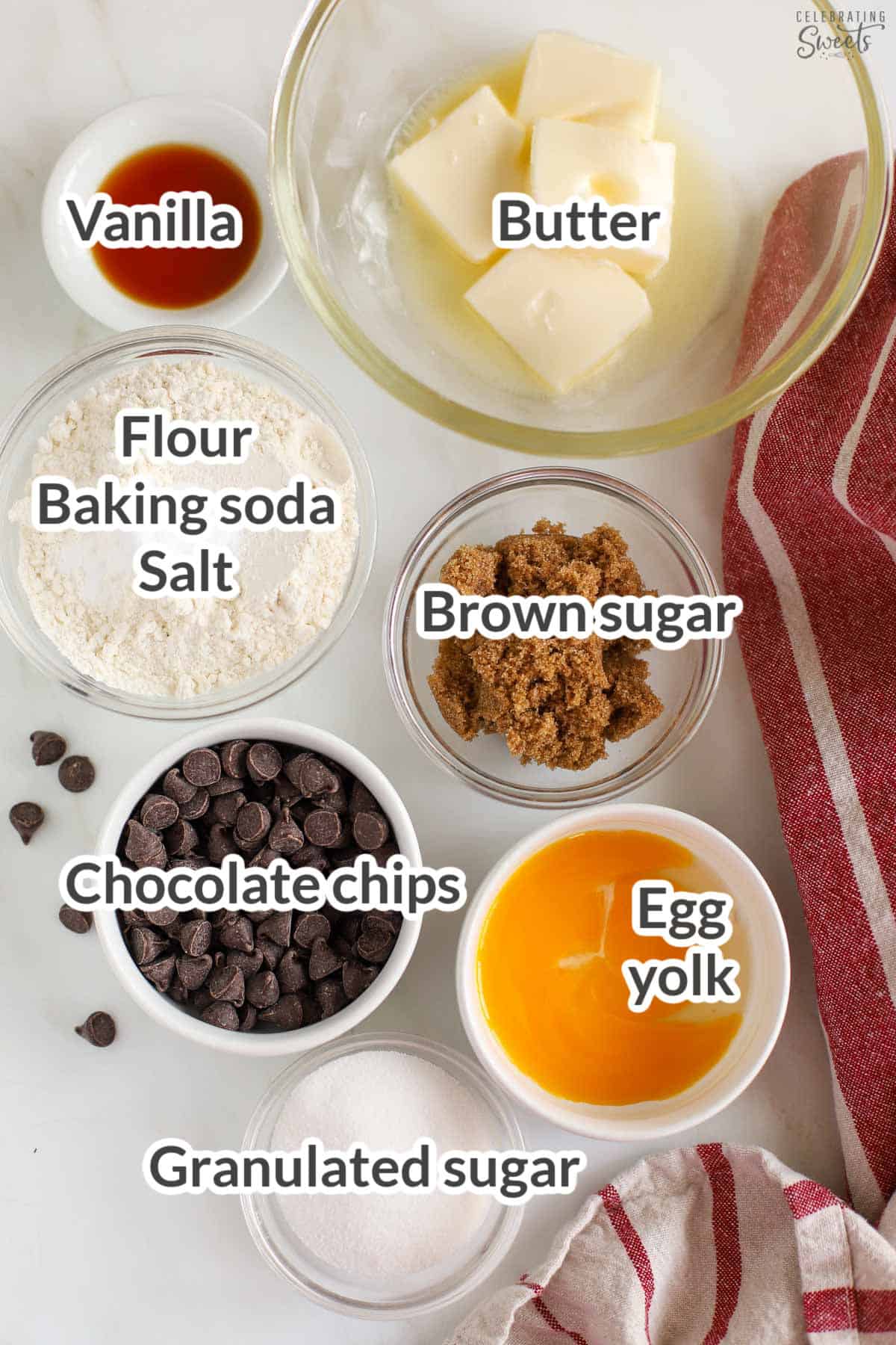 Ingredients to make a small batch of chocolate chip cookies (sugars, egg yolk, flour, chocolate chips, baking soda, salt, butter, vanilla).