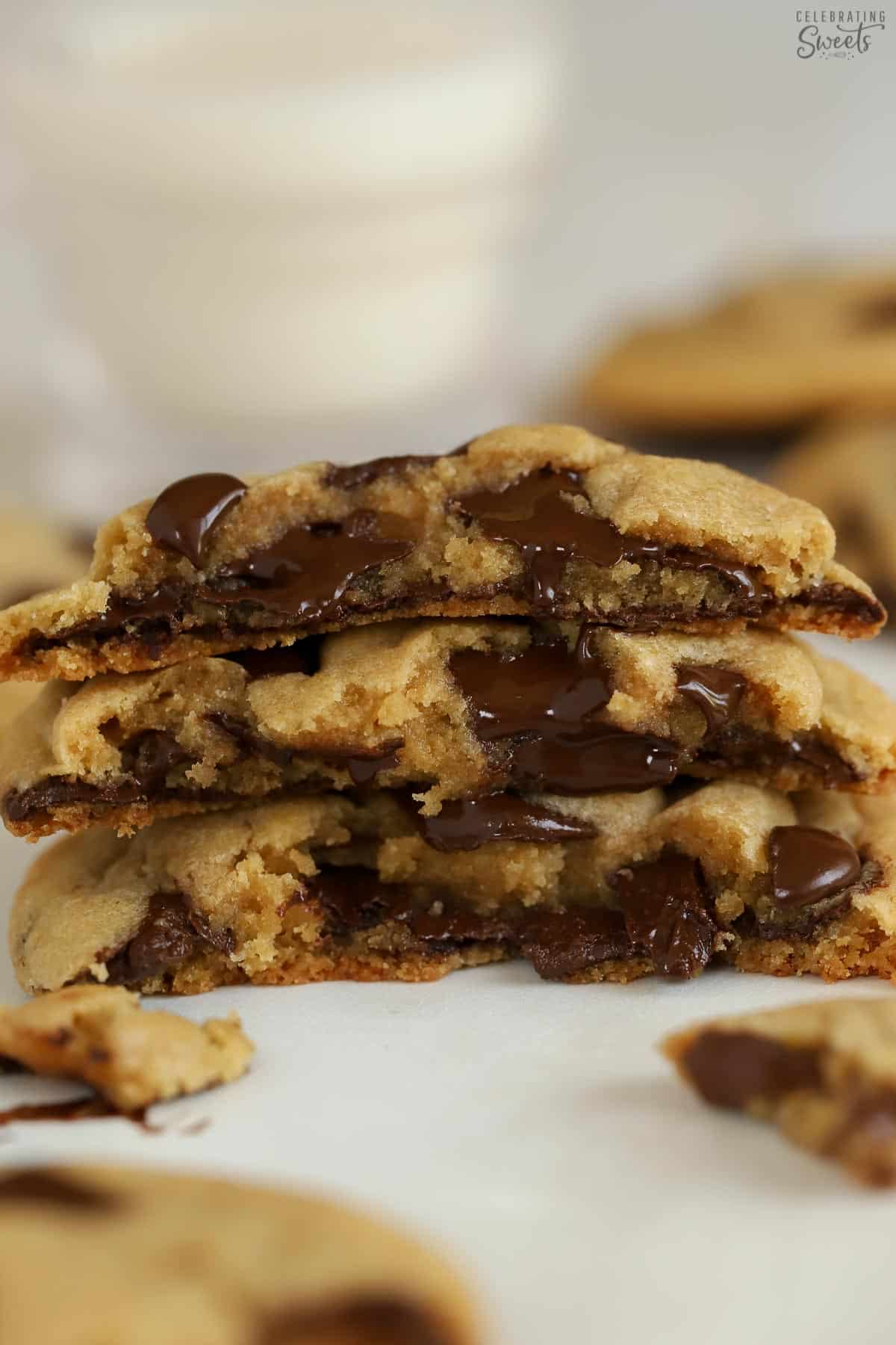 Stack of three chocolate chip cookies with melty chocolate chips.