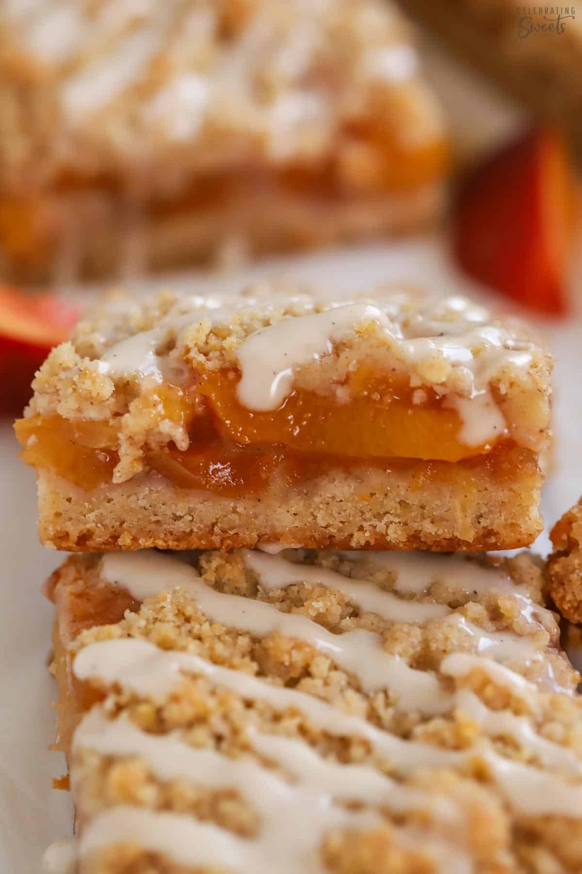 Closeup of a peach bar drizzled with white icing.