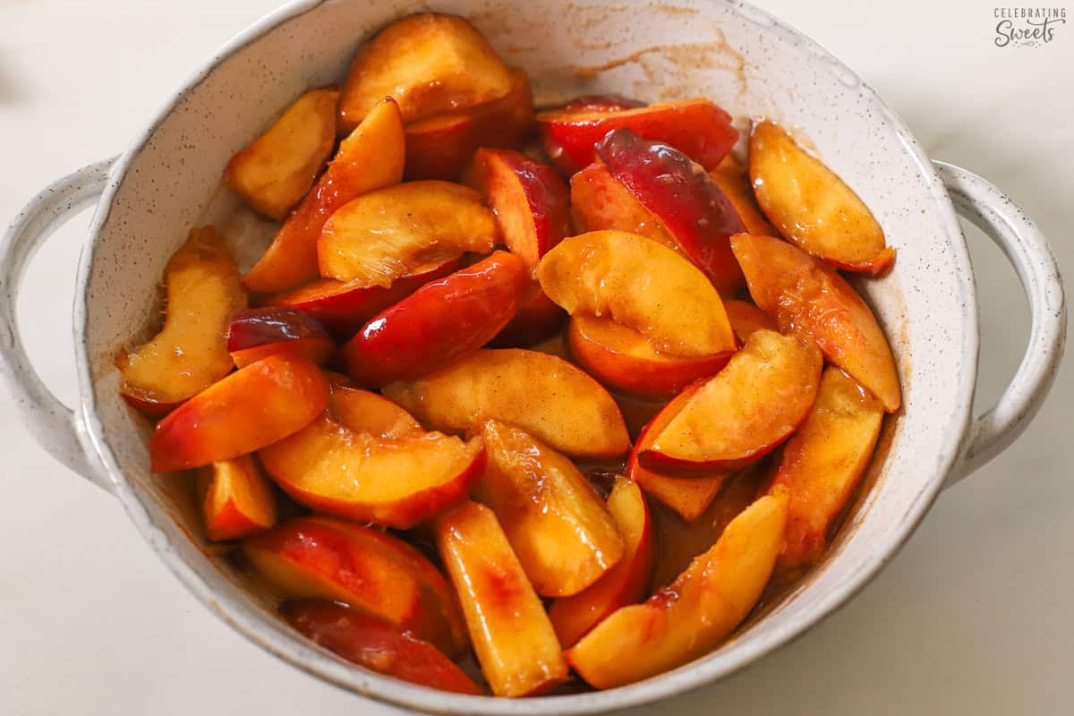 Sliced peaches in a round grey baking dish.