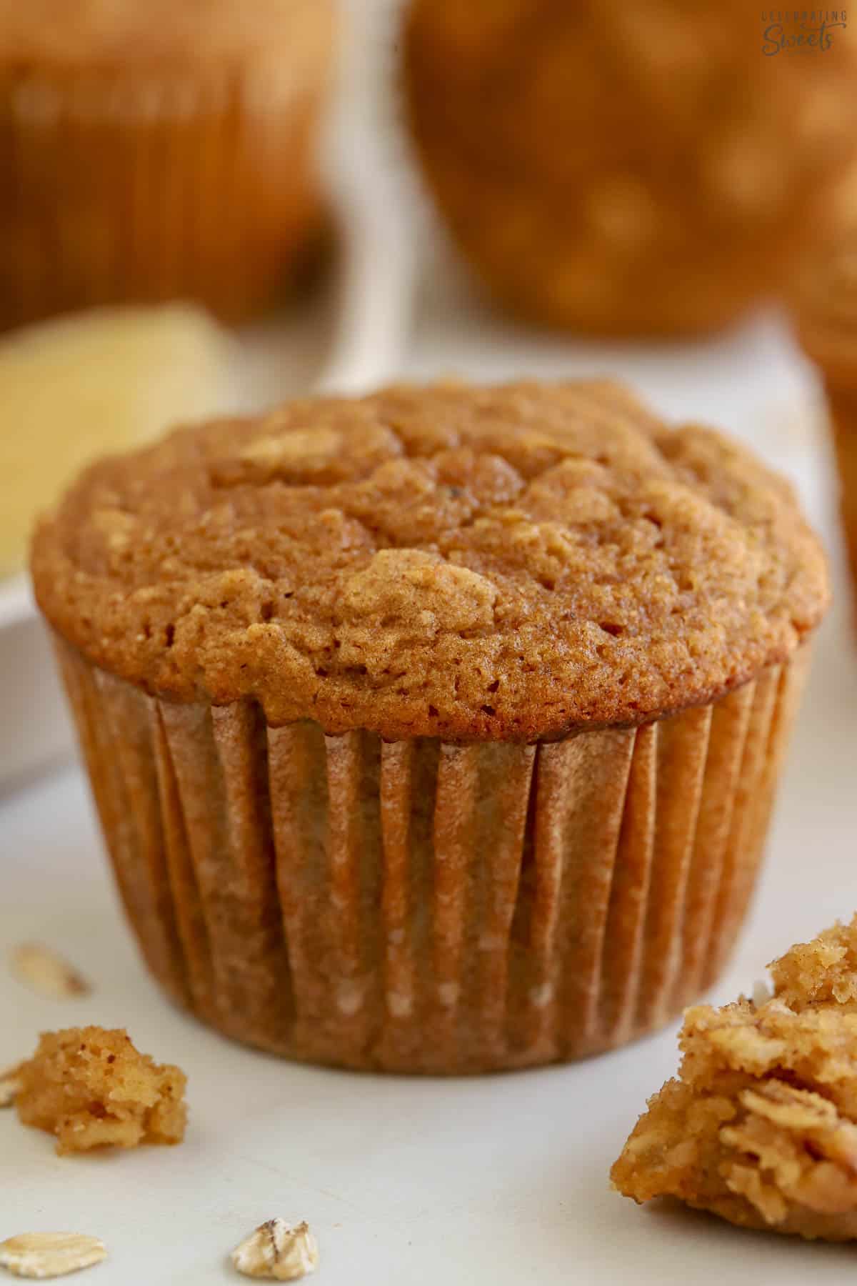 Closeup of an apple oatmeal muffin in a beige cupcake liner.