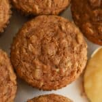 Overhead photo of an apple oatmeal muffin next to a spoon of applesauce.