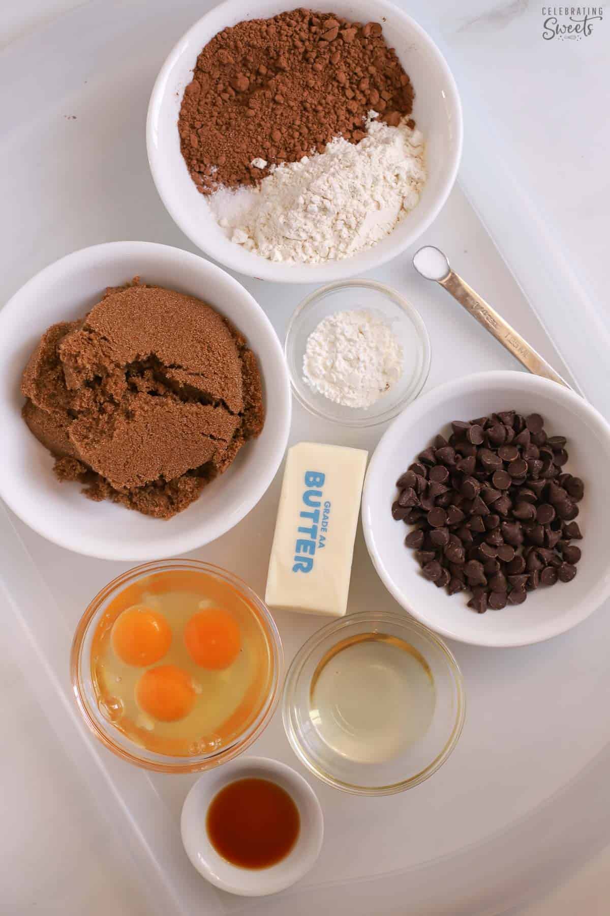 Ingredients for chewy brownies: sugar, cocoa, butter, oil, eggs, vanilla, flour, salt, chocolate chips.