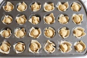 Unbaked almond croissant bites in a mini muffin pan.