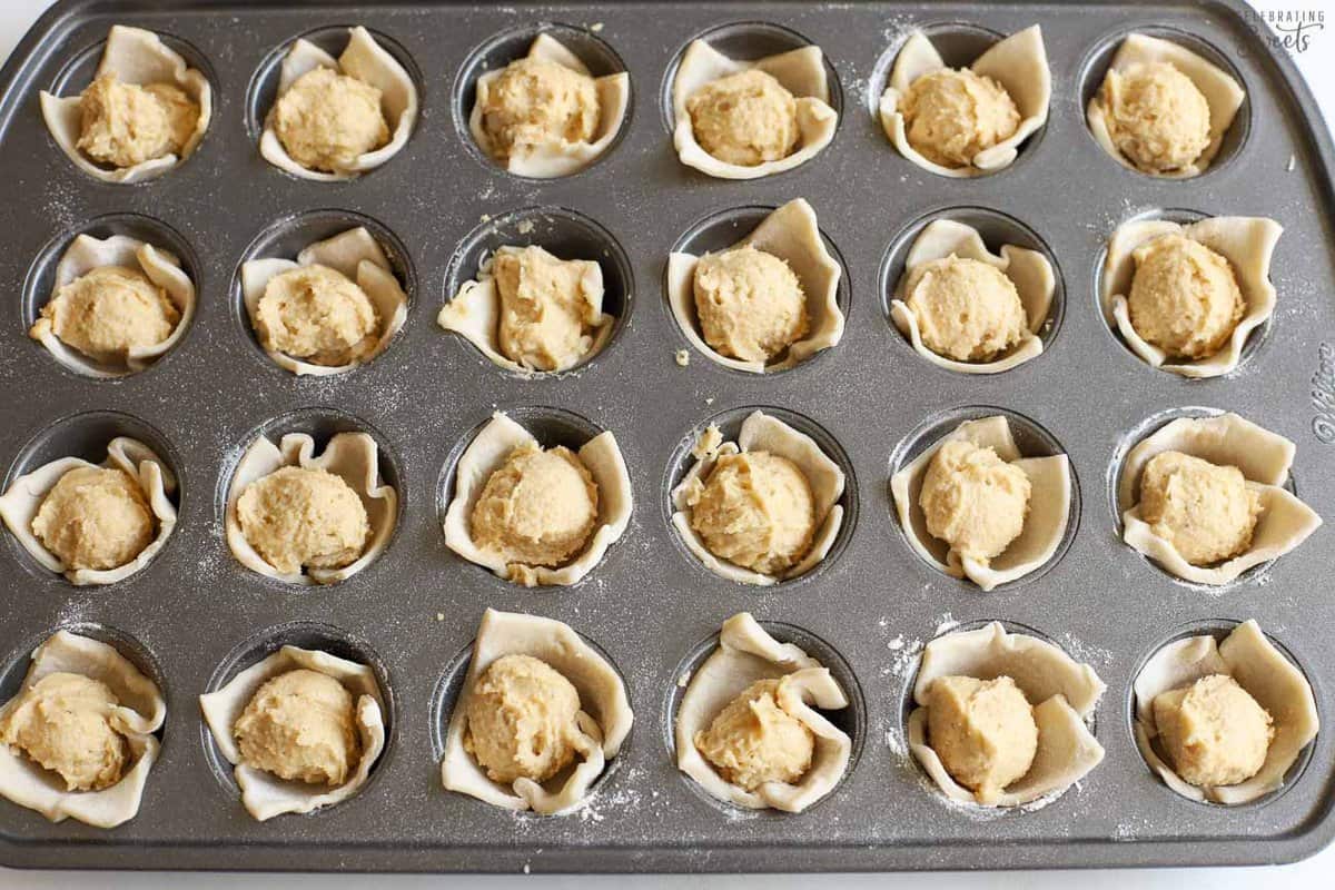 Unbaked almond croissant bites in a mini muffin pan.