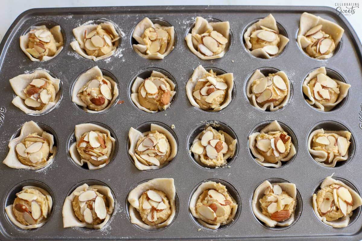 Unbaked almond croissant bites in a 24-count mini muffin pan.