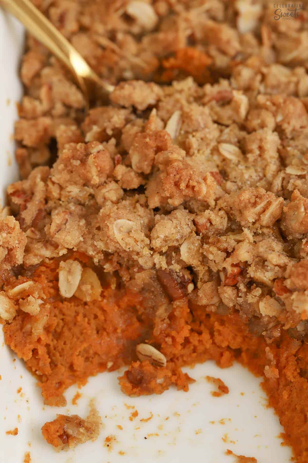 Closeup of a pumpkin crisp in a white baking dish.