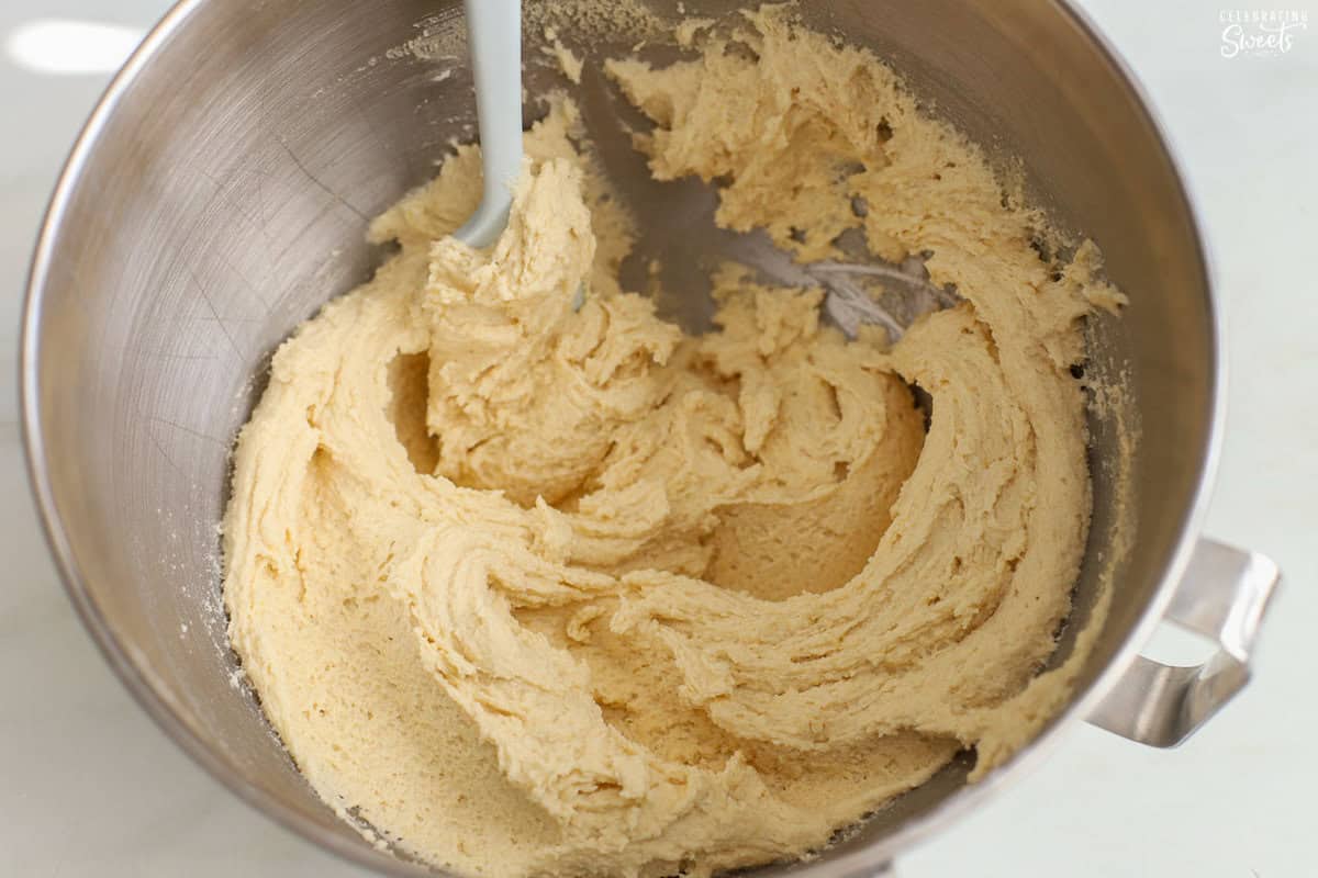 Sugar cookie dough in a stainless bowl.