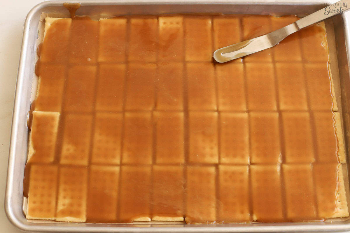 Crackers on a baking sheet topped with toffee.