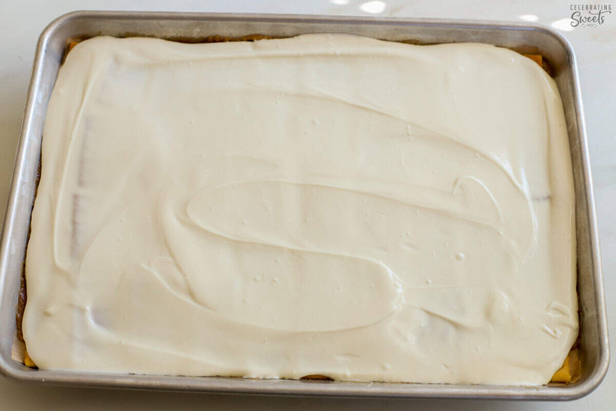 Toffee on a baking sheet topped with melted white chocolate.