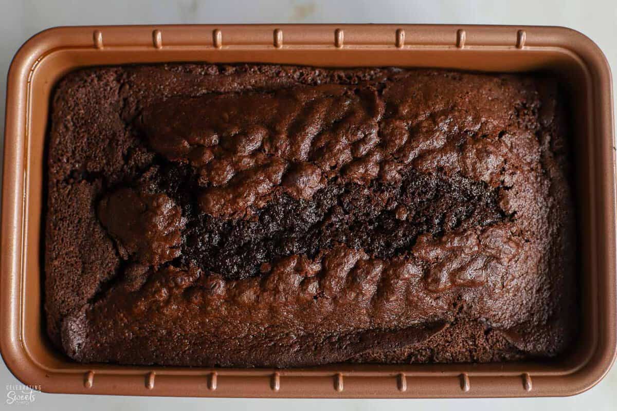 Chocolate loaf cake in a copper loaf pan.