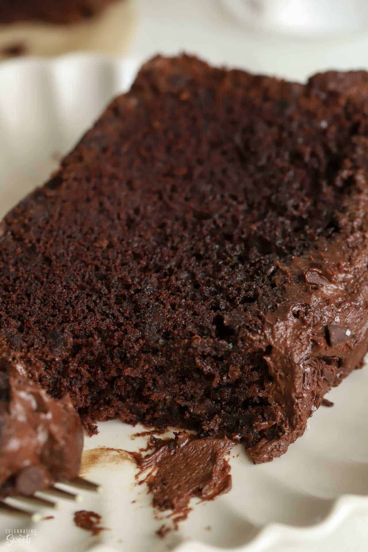 Close up of a slice of chocolate loaf cake on a white plate.