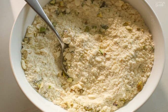 Shortbread crumble in a white bowl with a silver spoon.