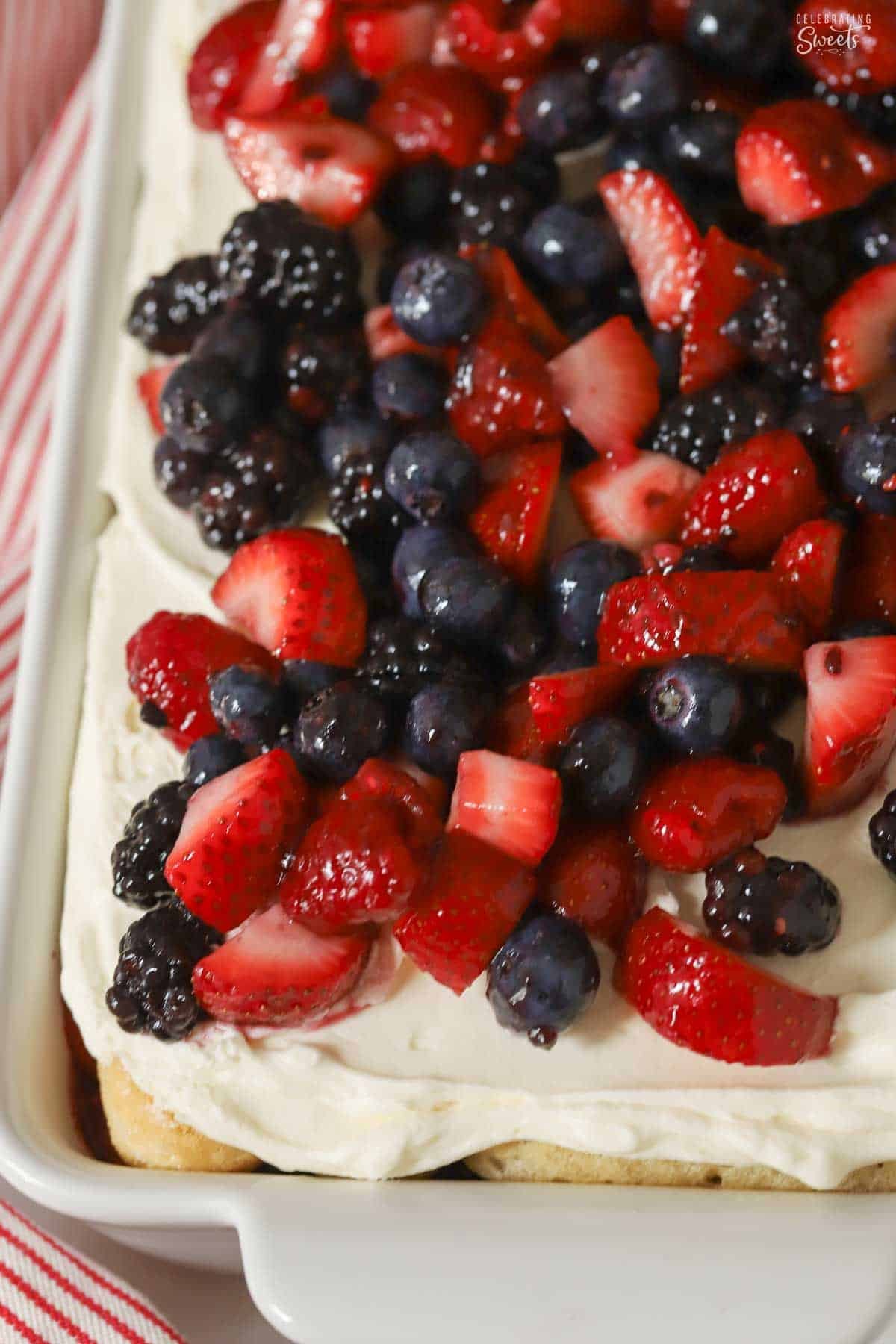 Overhead shot of berry tiramisu in a white baking dish topped with mixed berries.