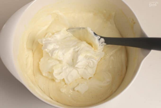 No-churn vanilla ice cream batter in a white bowl with a grey spatula.
