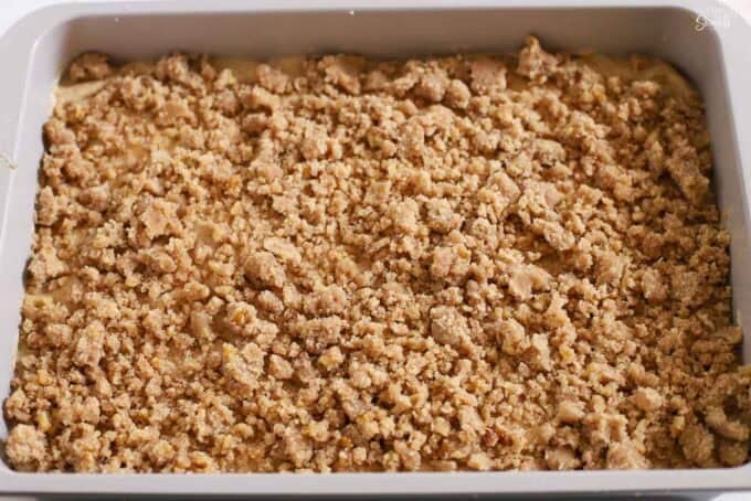 Unbaked apple crumb cake in a metal rectangular baking pan.
