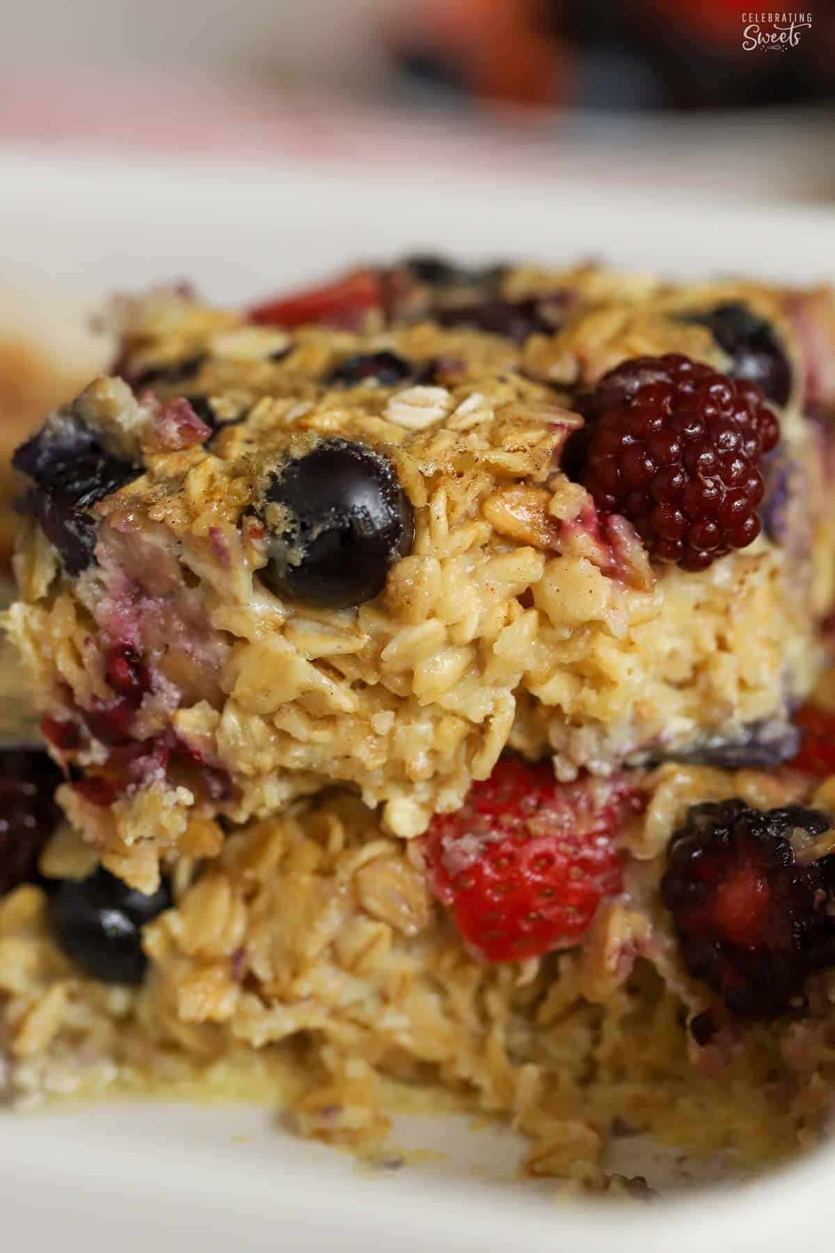 Baked oatmeal and mixed berries in a white dish.