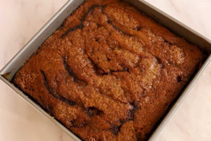 Pumpkin pudding cake in a square metal pan.