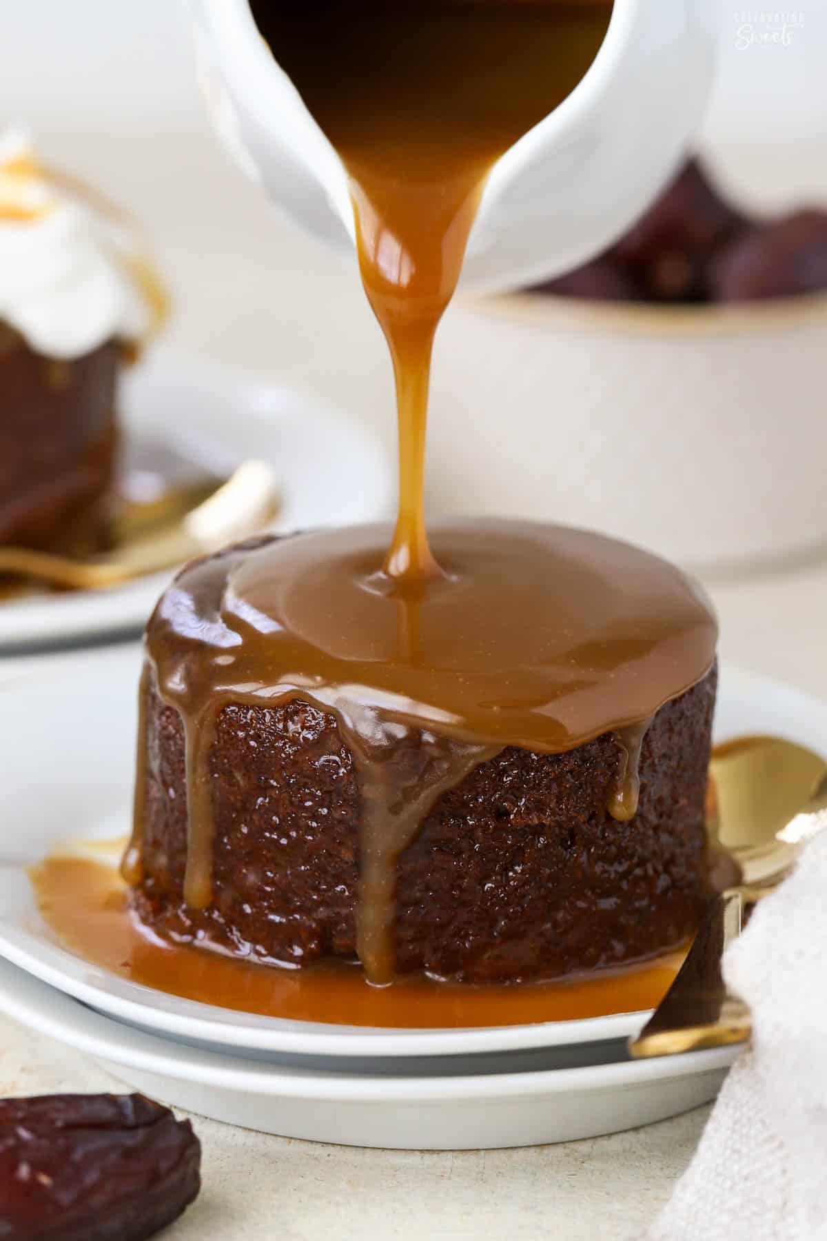 Toffee sauce being poured on sticky toffee pudding.