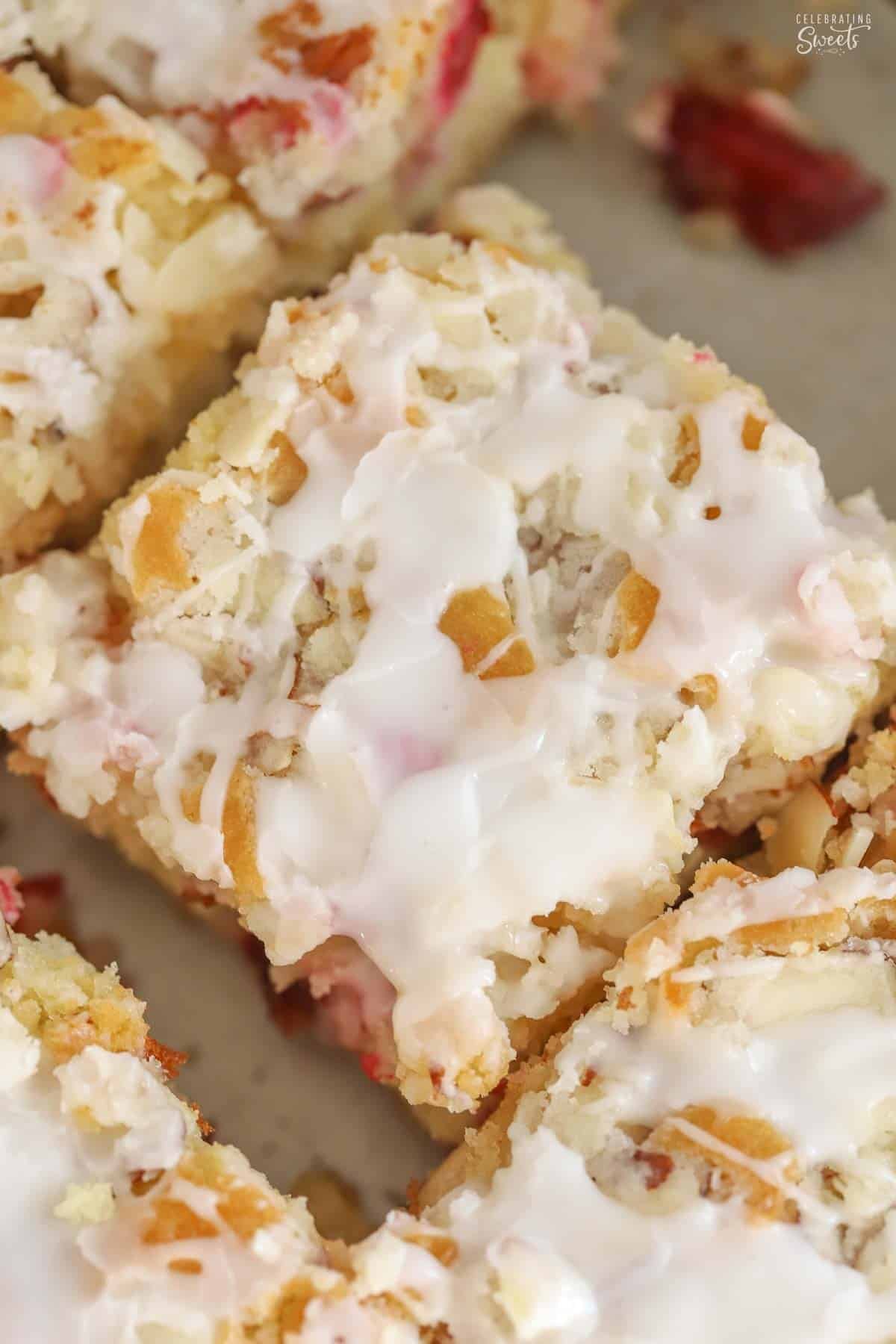 Overhead shot of a square slice of cranberry cake topped with white icing.