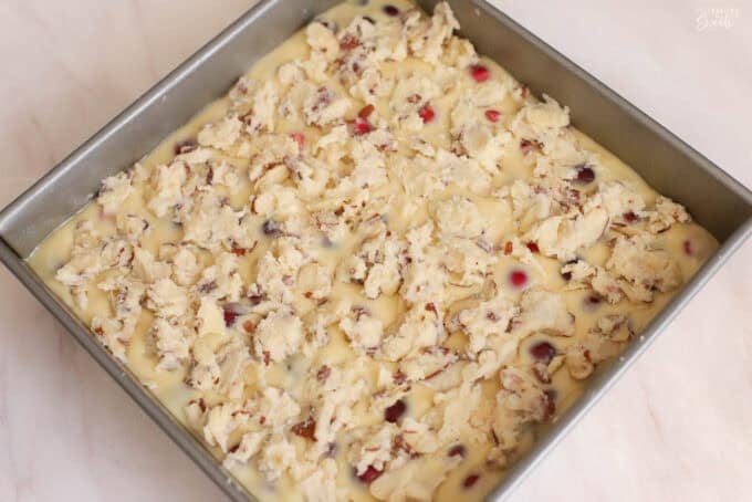 Cranberry cake batter in a square metal pan.