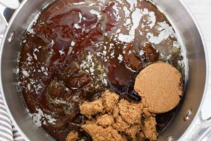 Pecan pie filling (brown sugar, melted butter, and maple syrup) in a saucepan.