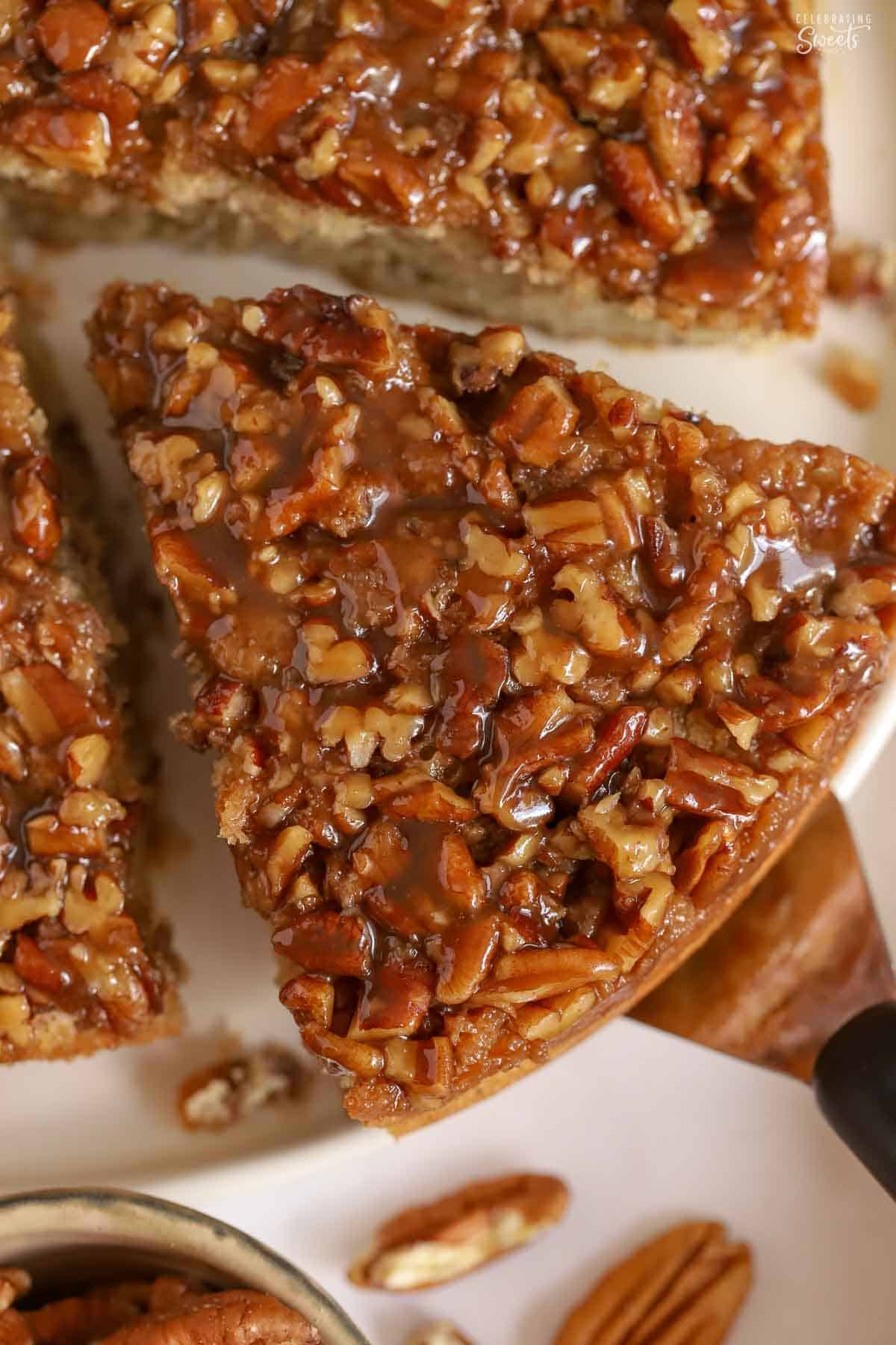 Overhead shot of a slice of pecan pie cake on a white plate.