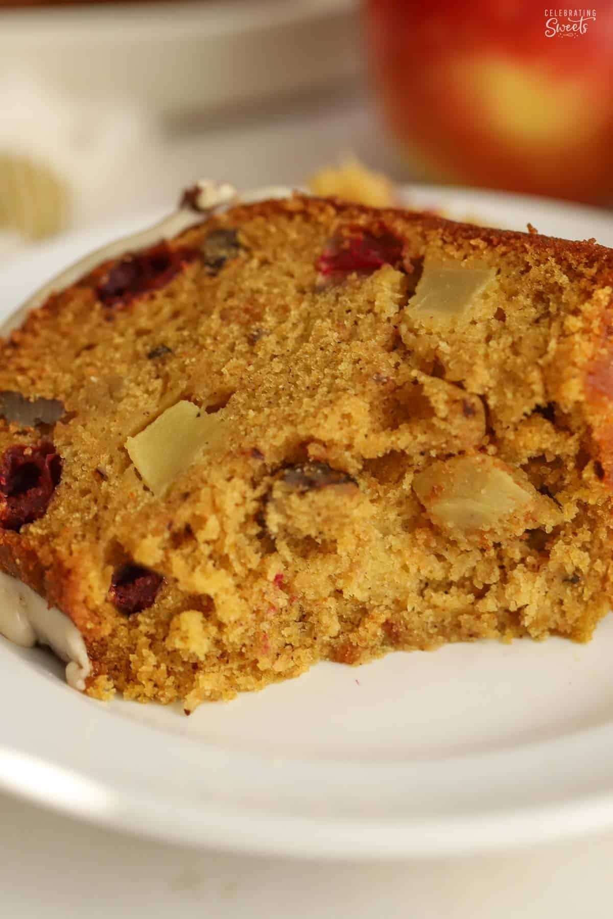 Slice of pumpkin cranberry apple bundt cake with a bite taken out of it.