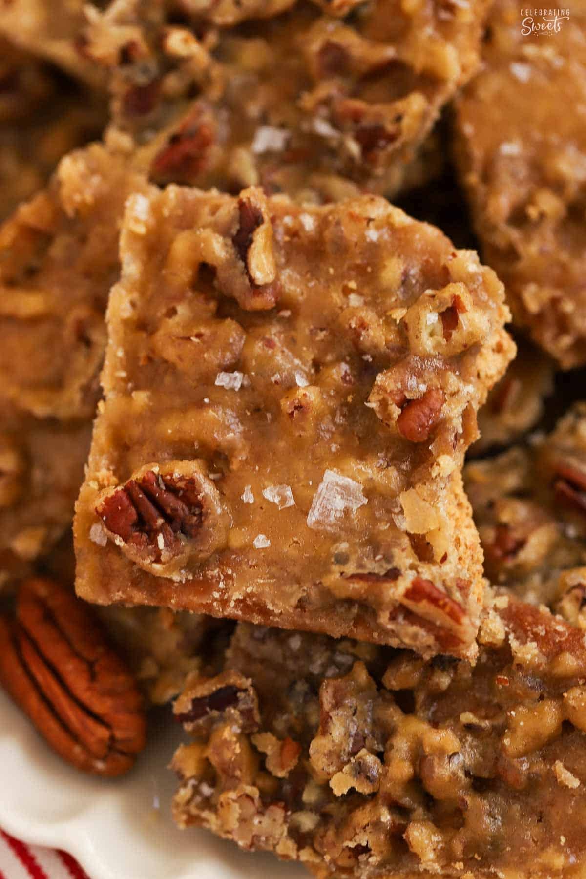 Closeup of toffee bark topped with pecans and flaky sea salt.