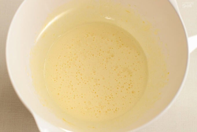 Light yellow batter in a large white bowl.