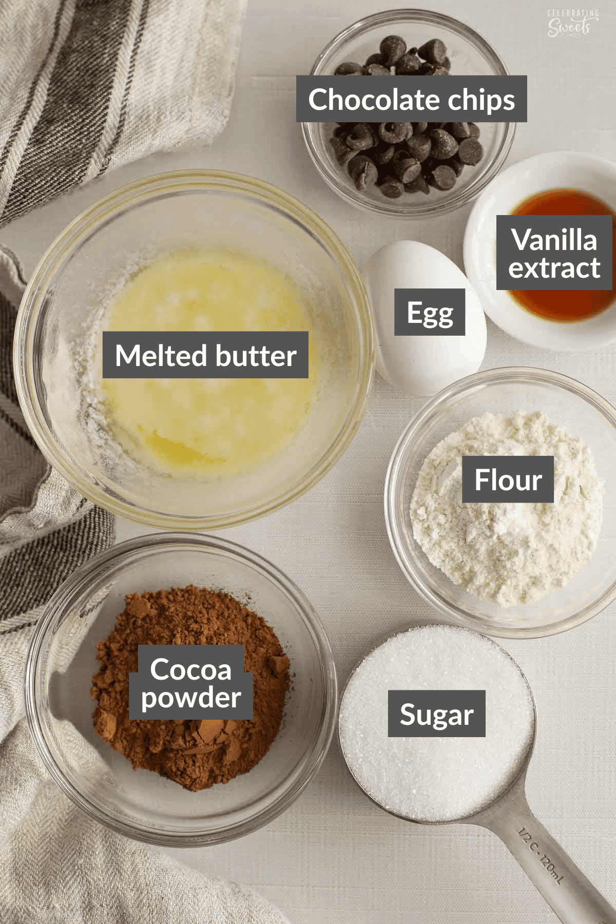 Ingredients for brownie pudding: cocoa powder, flour, sugar, chocolate chips, egg, butter, vanilla.