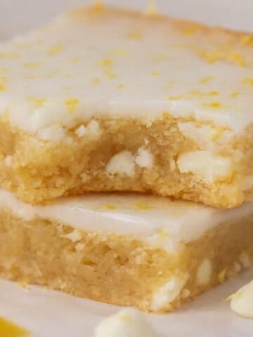 Stack of two lemon brownies topped with white icing.