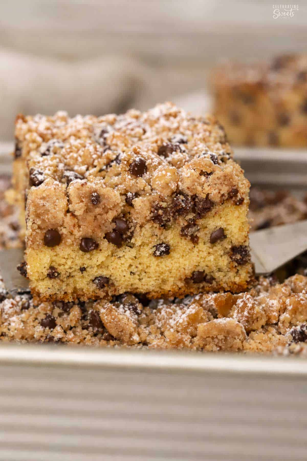 A slice of chocolate chip crumb cake on a metal spatula.