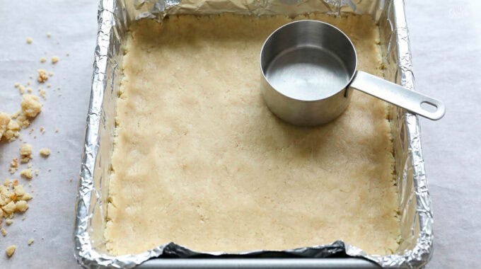 Shortbread crust pressed into bottom of foil-lined baking pan.