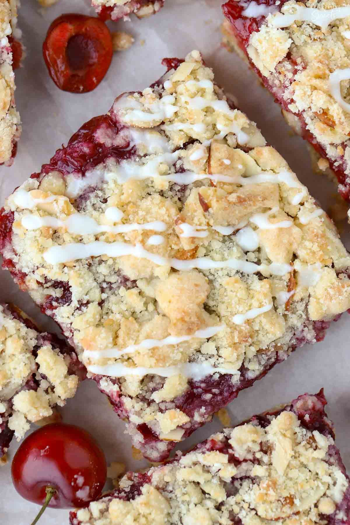 Overhead of cherry crumb bar drizzled with white icing.