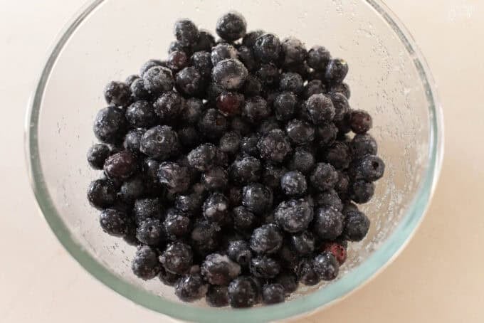 Glass bowl filled with blueberries tossed in sugar.