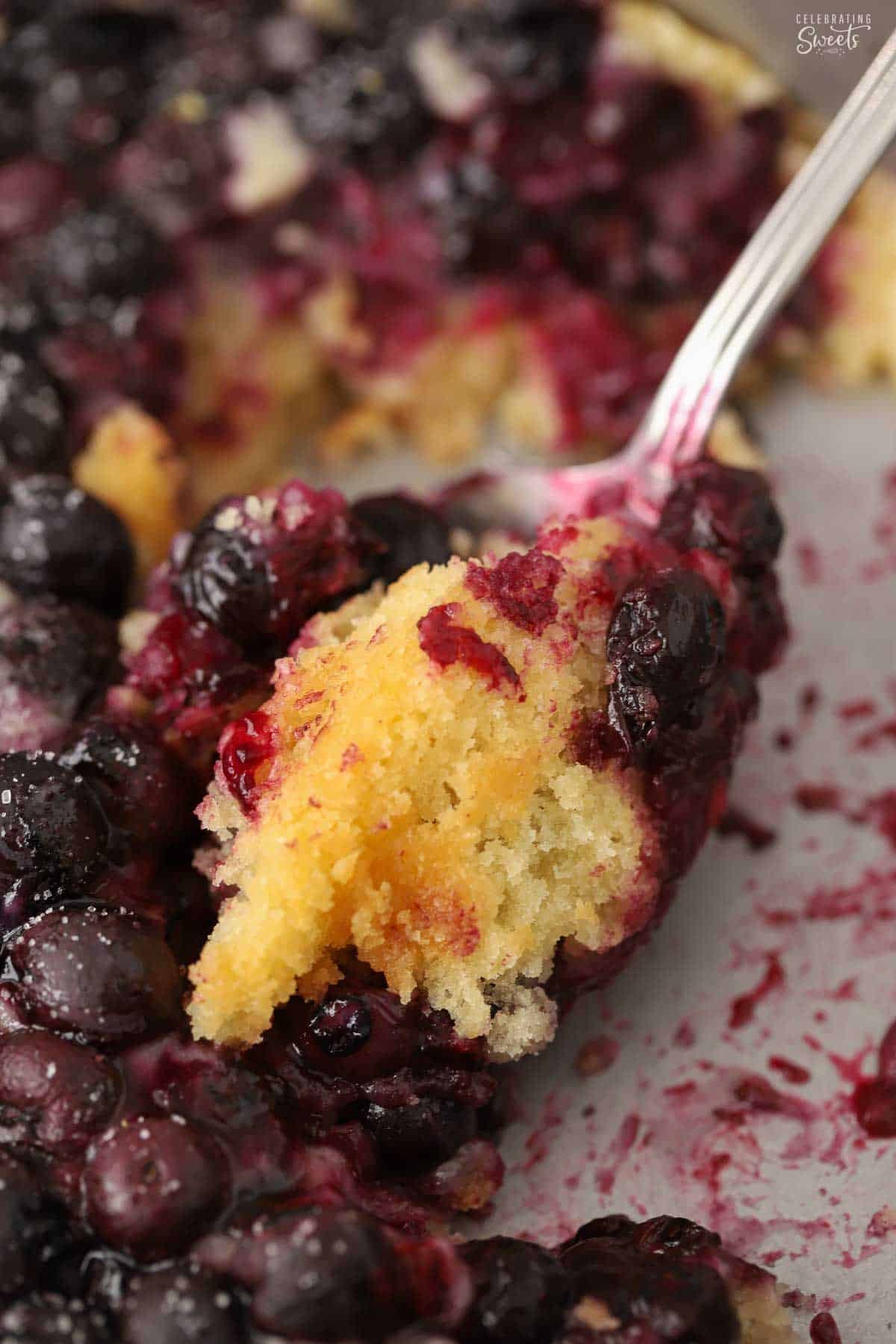 Lemon blueberry spoon cake on a spoon in a metal pan.