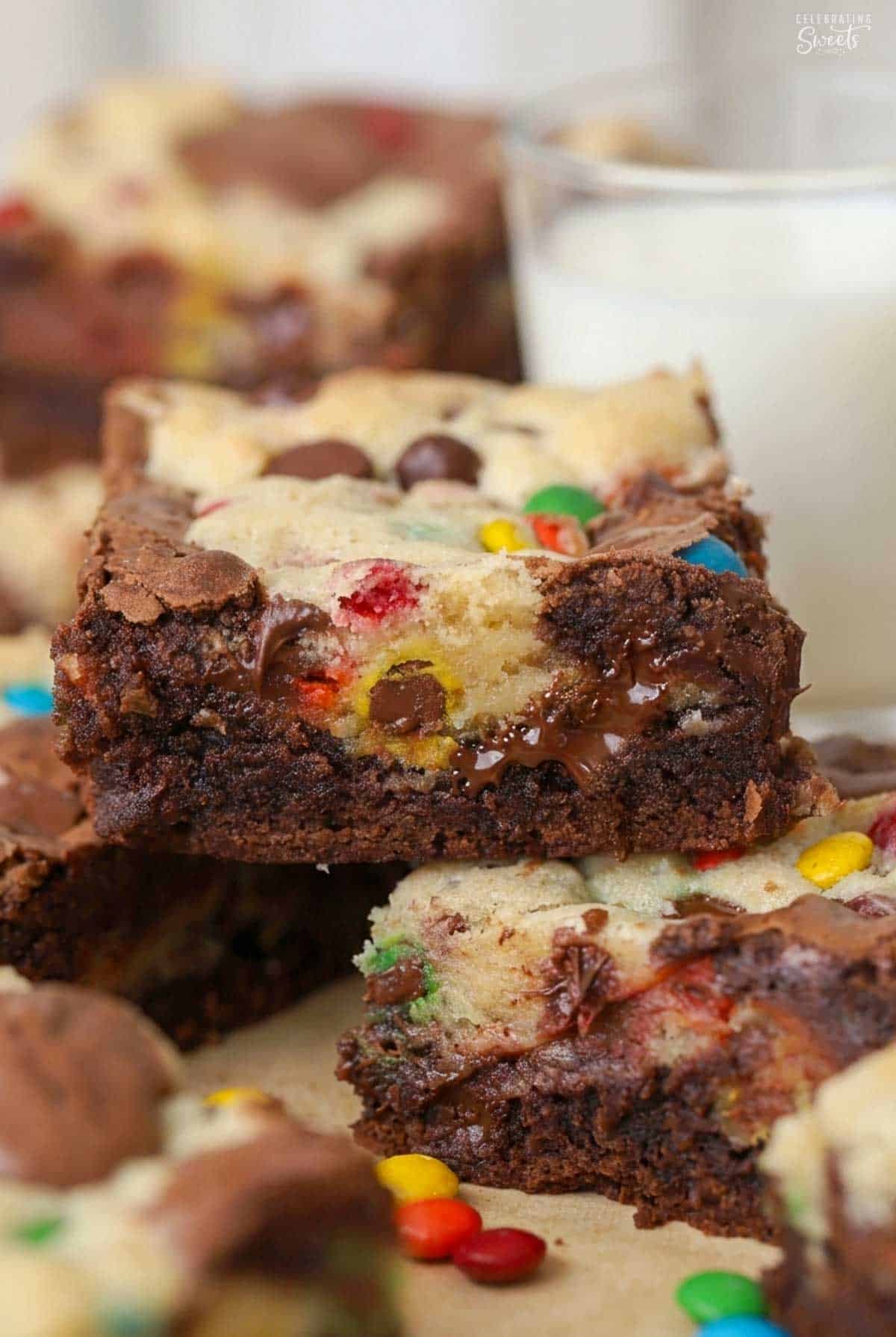 M&M brookie bars stacked on a piece of parchment paper.