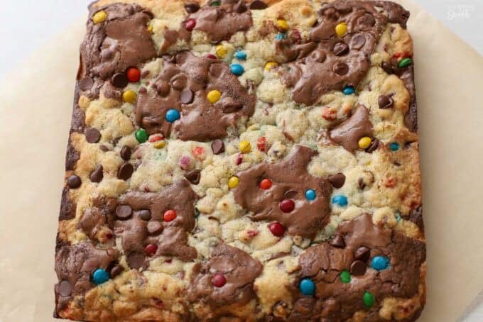 Square pan of M&M brookies on parchment paper.