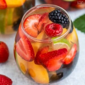 White sangria and fresh fruit in a stemless wine glass.