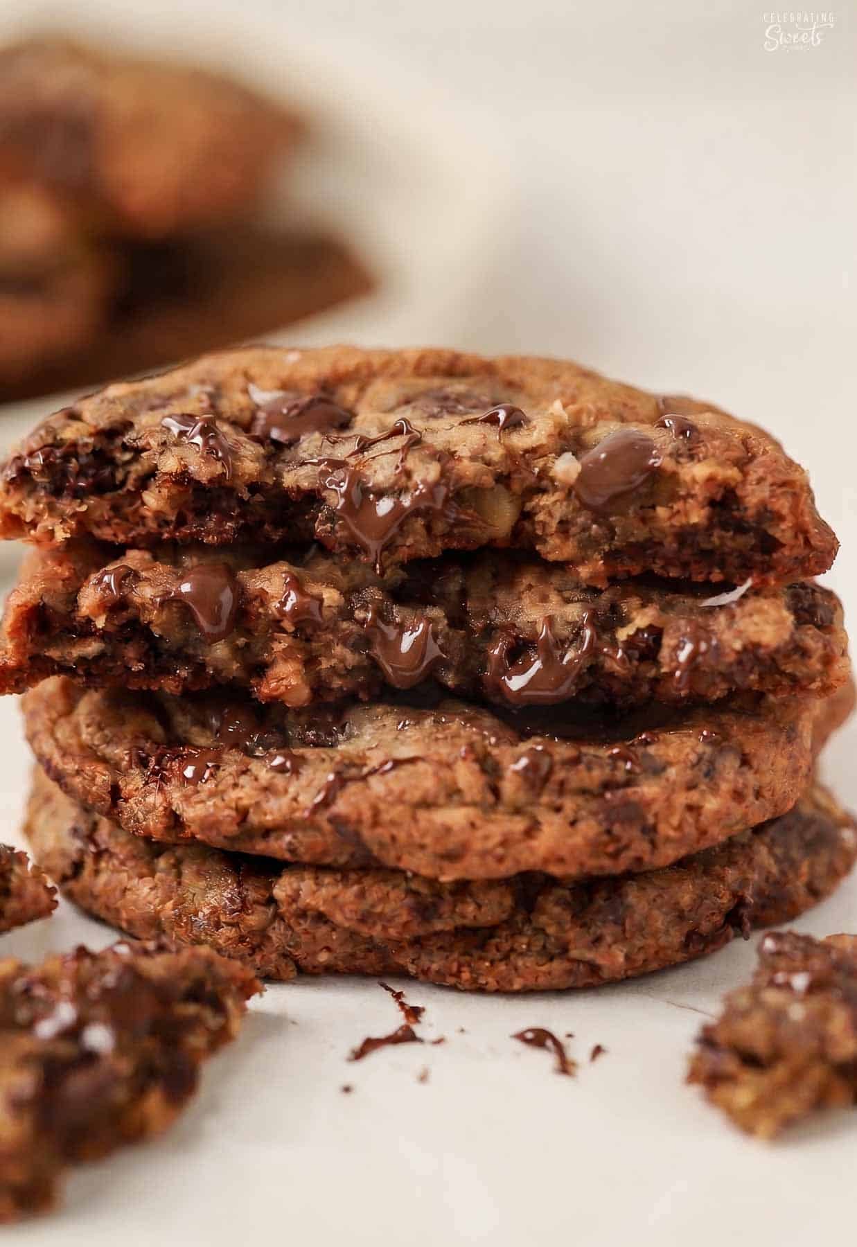 Stack of three oatmeal chocolate chip cookies with bits of melted chocolate.