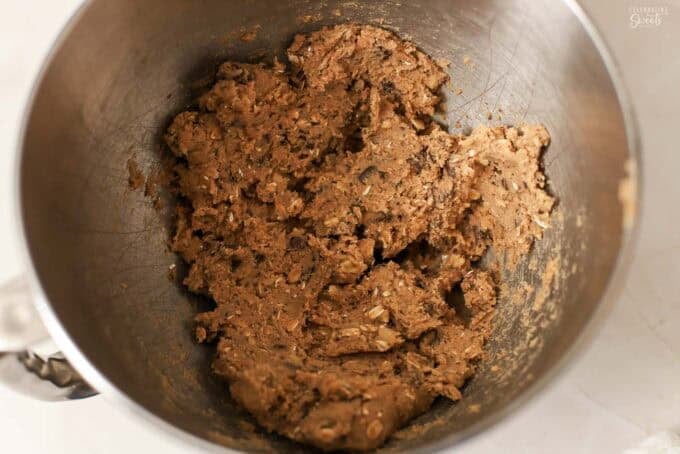 Oatmeal chocolate chip cookie dough in a metal bowl.
