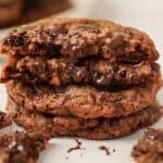 Stack of three oatmeal chocolate chip cookies with bits of melted chocolate.