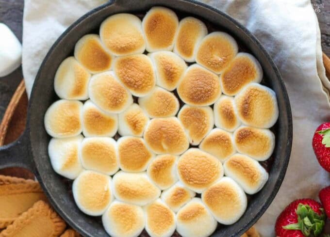 S'mores dip in cast iron skillet on top of a grey napkin.
